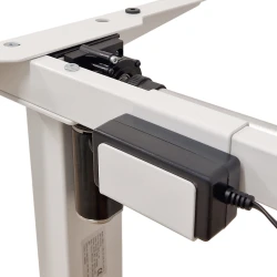 Zasilacz biurka BIMOTION, zamocowany do białego metalowego stelażu, zbliżenie na element elektroniczny.